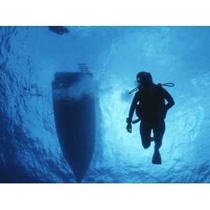  A Silhouetted Diver Descends into Clear Blue Water Premium 
